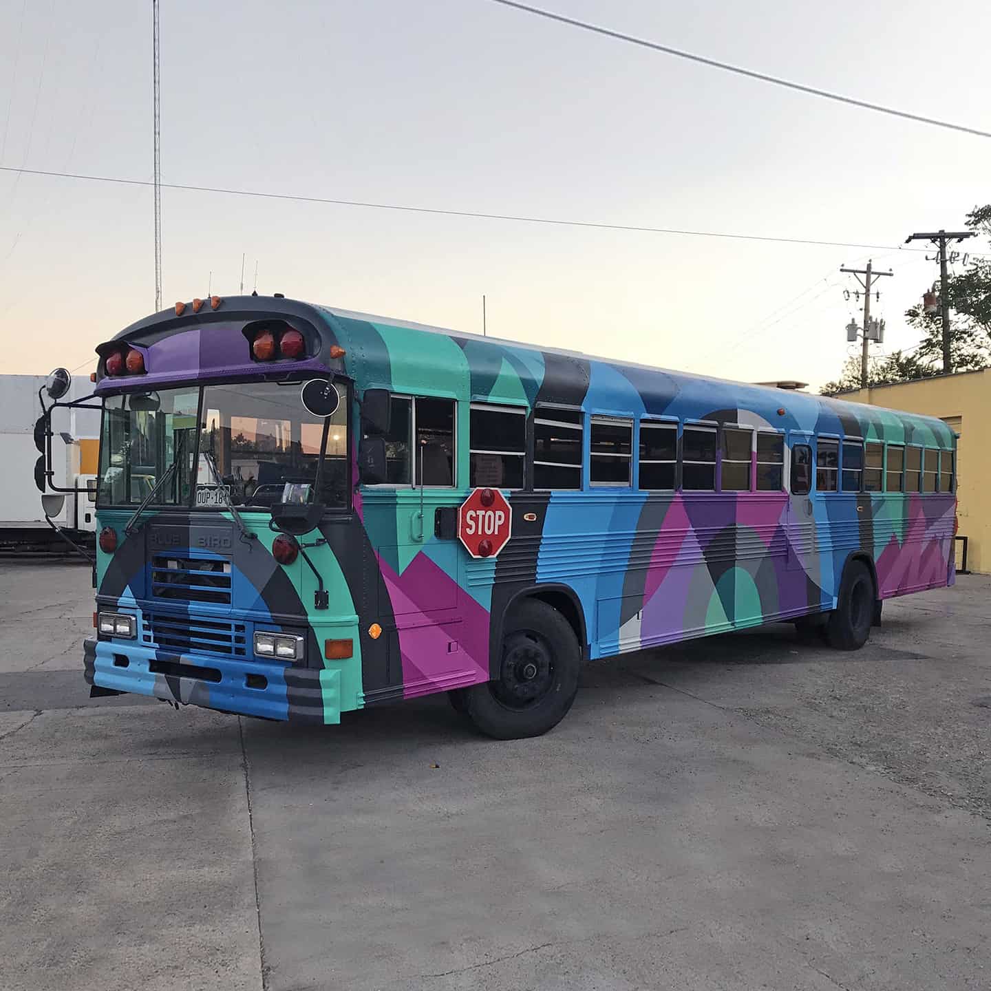 Denver street artist Jason T. Graves paints school bus for the Bus to Show company.